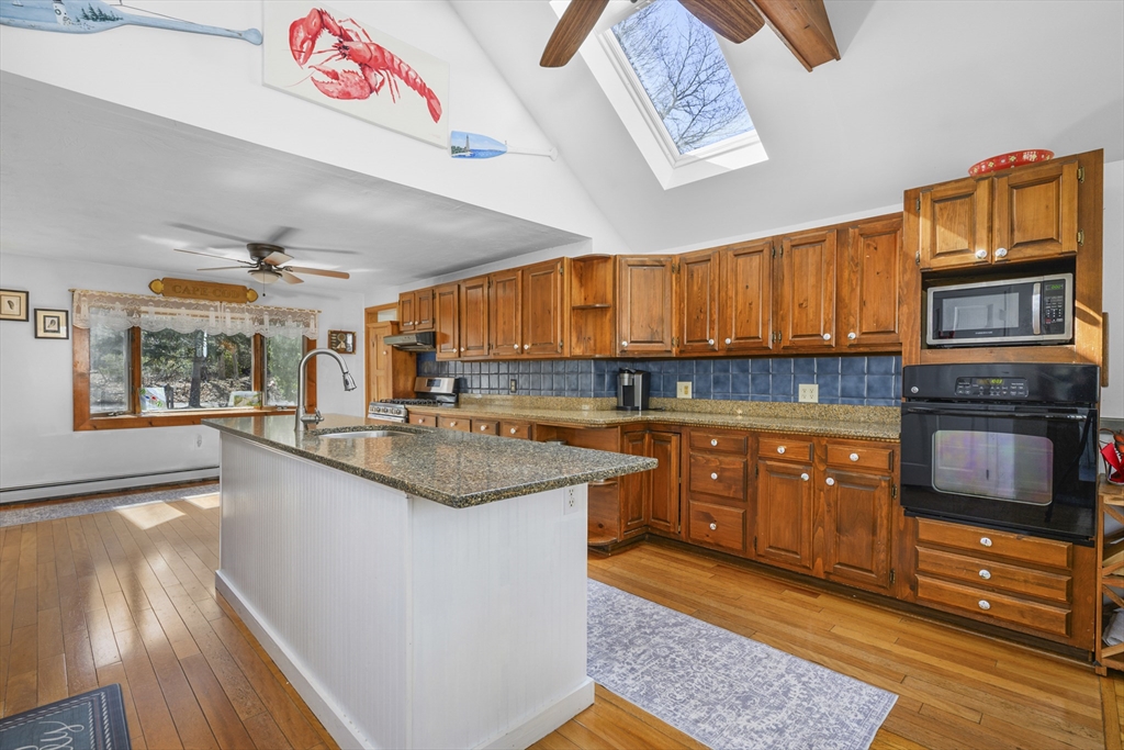 125 Wamsutta Road Eastham, MA 02642 - Photo 13 of 42 a kitchen with stainless steel appliances granite countertop a stove a sink and a microwave