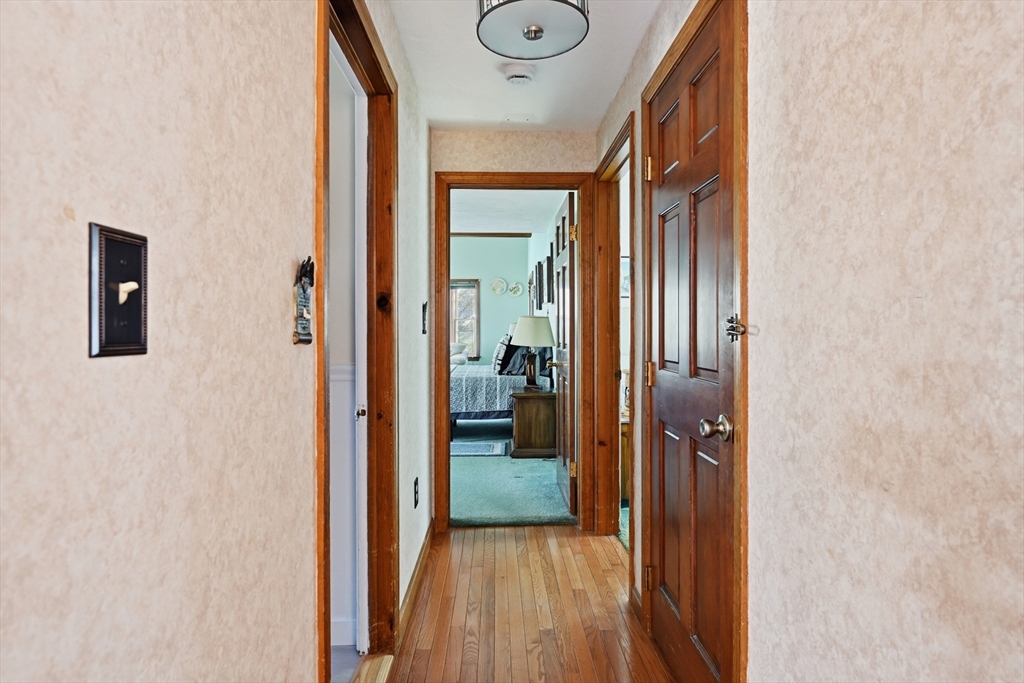 125 Wamsutta Road Eastham, MA 02642 - Photo 24 of 42 a view of a hallway with wooden floor and a livingroom with furniture