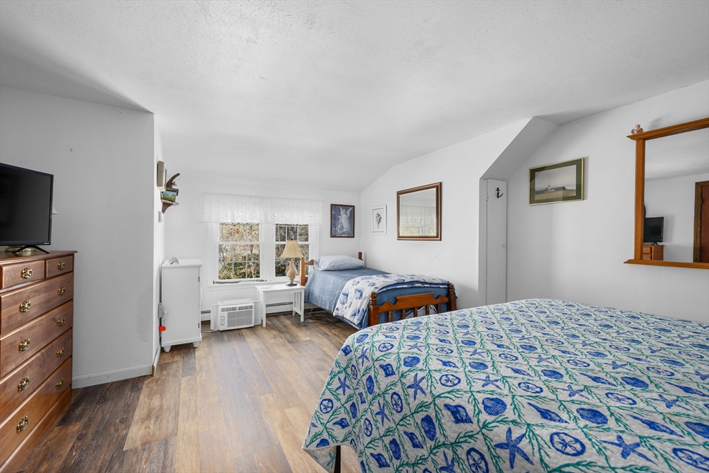 125 Wamsutta Road Eastham, MA 02642 - Photo 31 of 42 a bedroom with a bed and wooden floor