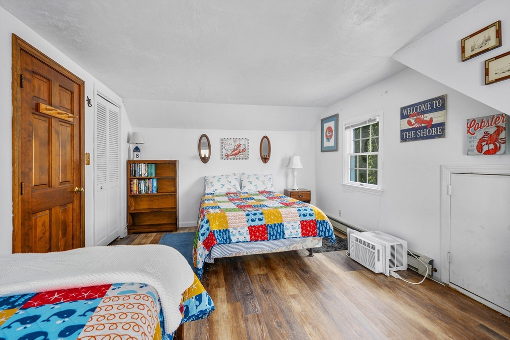 125 Wamsutta Road Eastham, MA 02642 - Photo 35 of 42 a bedroom with a bed and wooden floor
