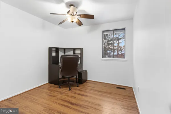 a view of workspace with wooden floor and ceiling fan