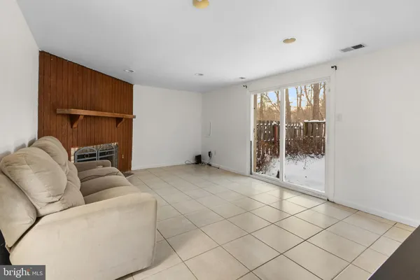 a living room with furniture a floor to ceiling window and a wooden floor
