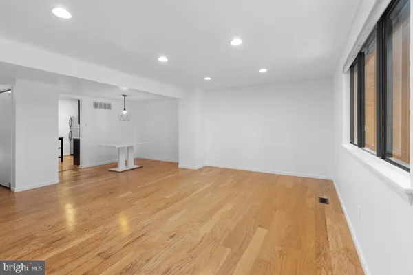 a view of empty room with wooden floor
