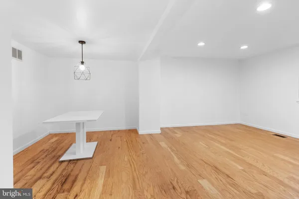 a view of a room with wooden floor and a ceiling fan