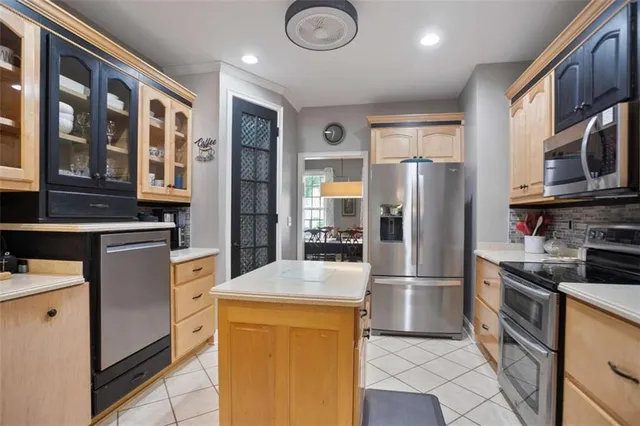 a kitchen with stainless steel appliances granite countertop a refrigerator and a stove top oven