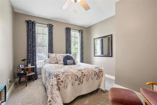 a bedroom with a bed a lamp and a large window