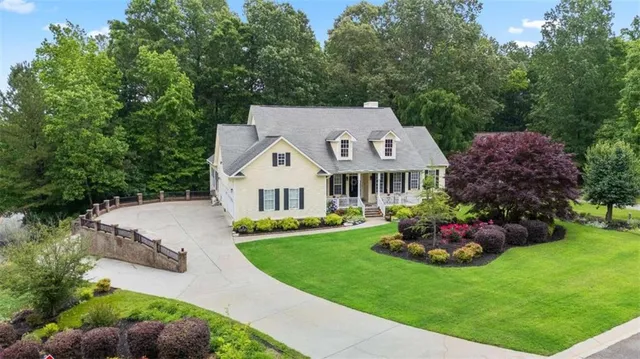 a front view of a house with a garden and trees