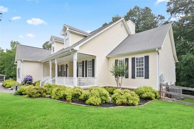 a front view of a house with a yard and potted plants
