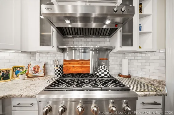 a view of a dining room and livingroom with furniture wooden floor a chandelier