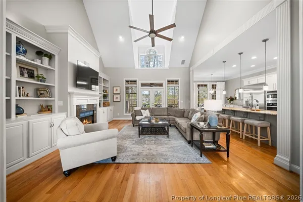 a large kitchen with cabinets chairs and wooden floor