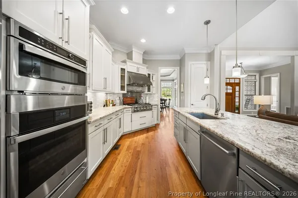 a large kitchen with stainless steel appliances granite countertop a lot of counter space and wooden floor