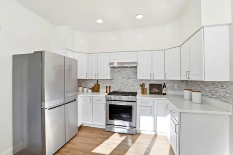 a kitchen with a refrigerator sink and cabinets