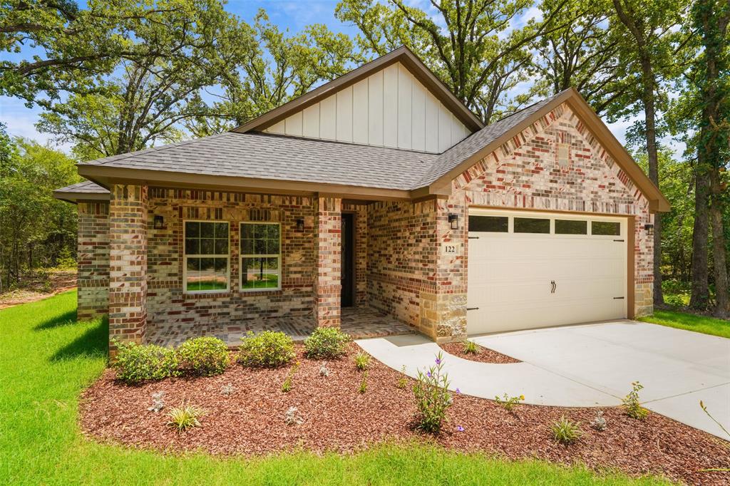 122 East Beachwood Loop Trinidad, TX 75163 - Photo 3 of 35 Brick and siding exterior featuring a covered front porch, an attached garage with decorative hardware, a concrete driveway, and established landscaping
