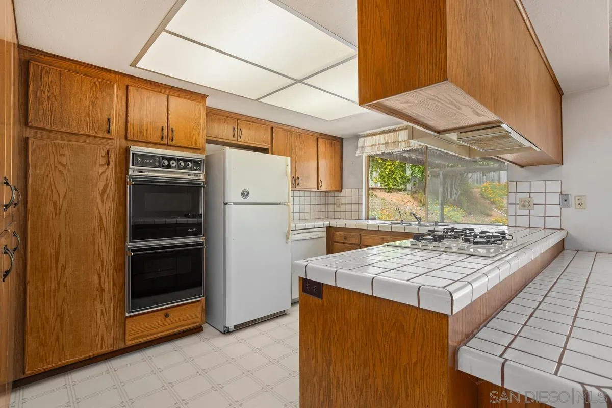 1740 Kirk Place Carlsbad, CA 92008 - Photo 8 of 22 a kitchen with stainless steel appliances granite countertop a stove and a refrigerator