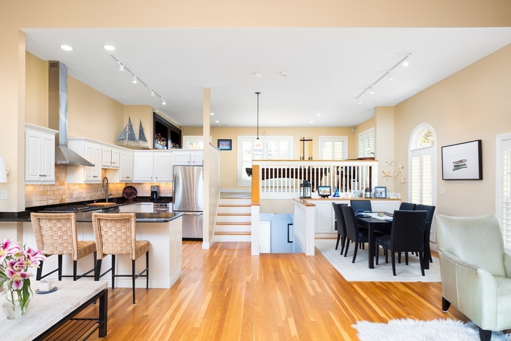 7 Cutter Lane, Unit 7 Quincy, MA 02171 - Photo 4 of 28 a kitchen with stainless steel appliances granite countertop dining table chairs and white cabinets