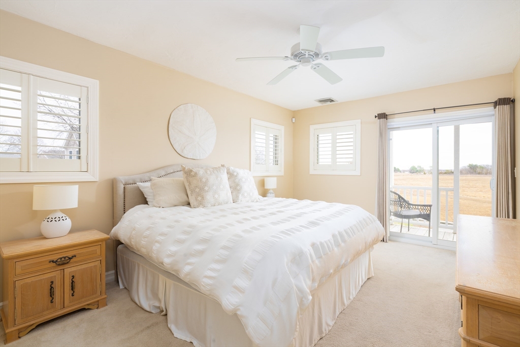 7 Cutter Lane, Unit 7 Quincy, MA 02171 - Photo 7 of 28 a bedroom with a large bed and a chandelier