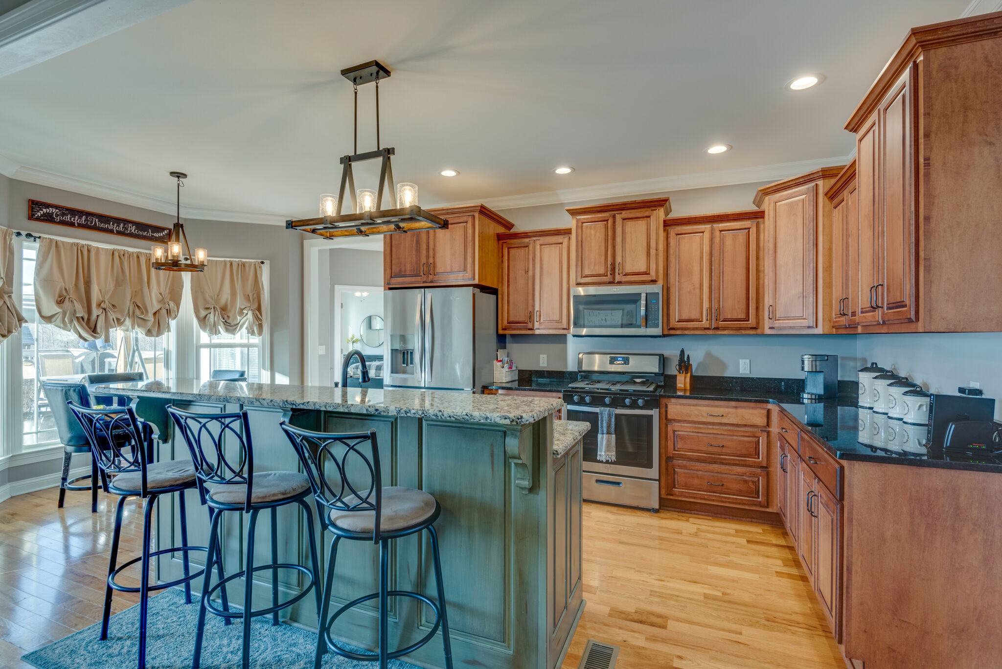 2822 Lock Hollow Road Dickson, TN 37055 - Photo 15 of 45 a kitchen with stainless steel appliances granite countertop a stove top oven a sink dishwasher a dining table and chairs with wooden floor