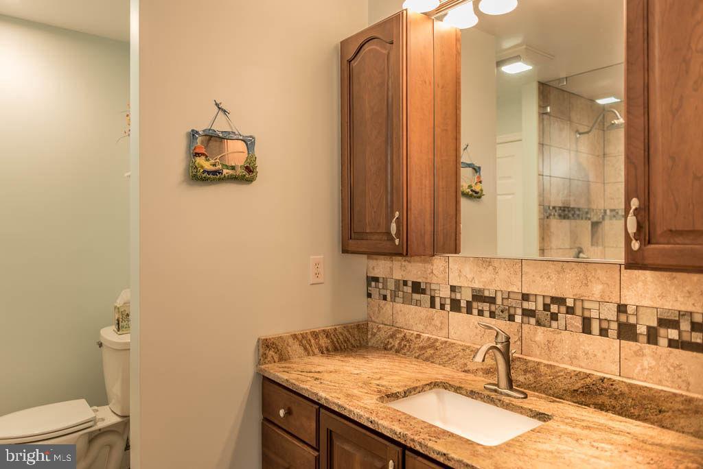 18 Brookside Road Berlin, MD 21811 - Photo 19 of 48 a bathroom with a granite countertop sink and a mirror