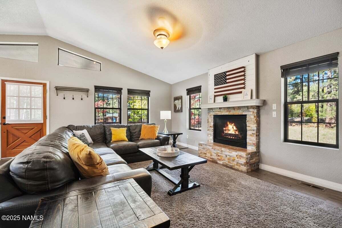 865 Caribou Road Munds Park, AZ 86017 - Photo 4 of 24 a living room with furniture and a fireplace