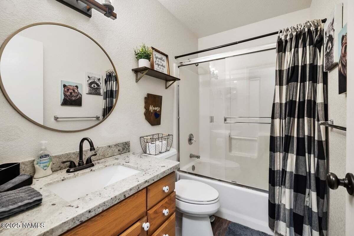 865 Caribou Road Munds Park, AZ 86017 - Photo 10 of 24 a bathroom with a granite countertop sink mirror vanity and toilet
