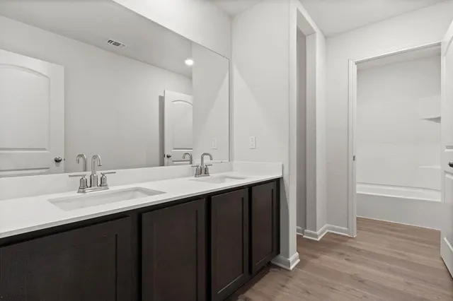 a bathroom with a double vanity sink and a mirror