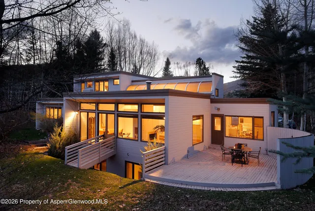 a front view of a house with garden and sitting area