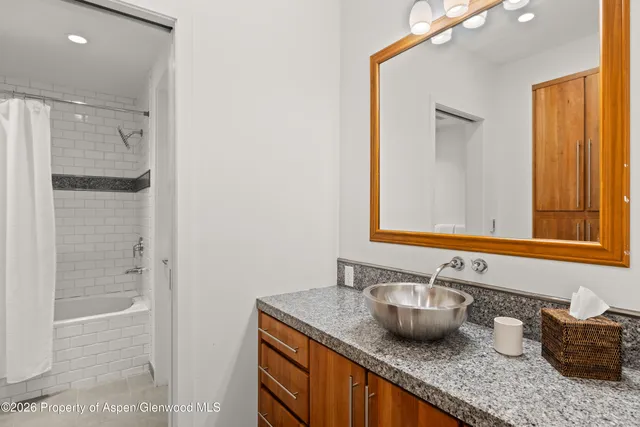 a bathroom with a granite countertop sink and a mirror