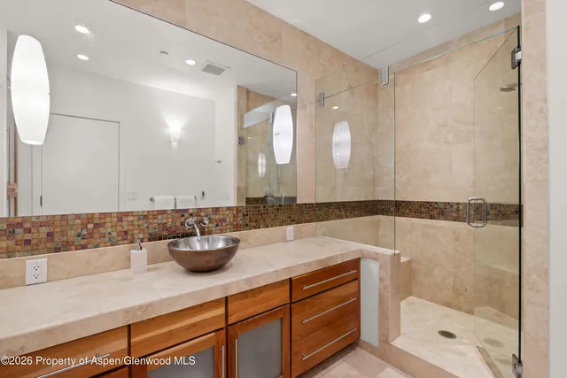 a bathroom with a shower sink and mirror