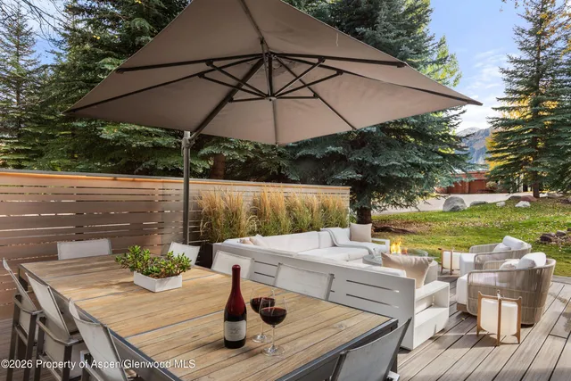 a view of a patio with table and chairs under an umbrella