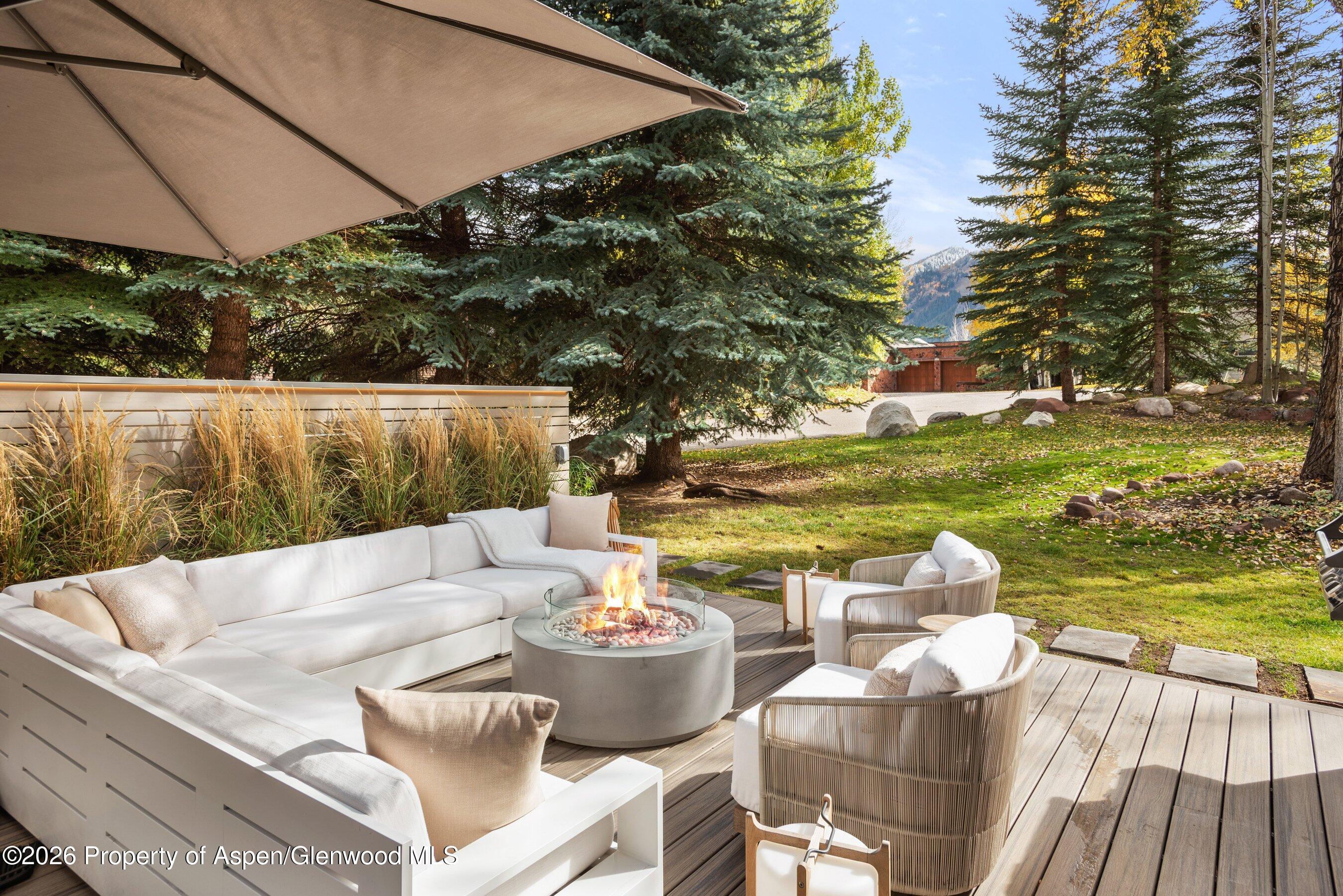 55 Overlook Drive Aspen, CO 81611 - Photo 7 of 25 a view of a patio with couches table and chairs under an umbrella