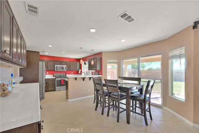 a kitchen with a table chairs sink and cabinets