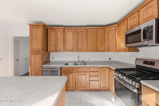 a kitchen with stainless steel appliances a stove a sink and a microwave