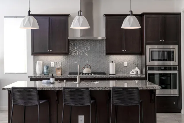 a kitchen with stainless steel appliances granite countertop a sink a stove and a refrigerator