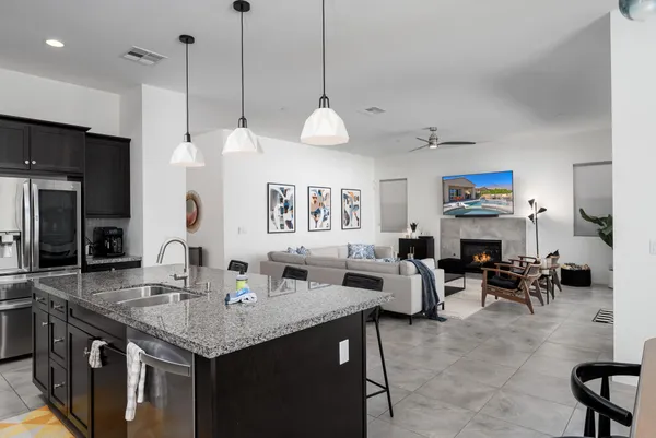 a kitchen with kitchen island granite countertop a sink a counter top space appliances and cabinets