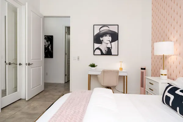 a bedroom with a bed and painting on the wall