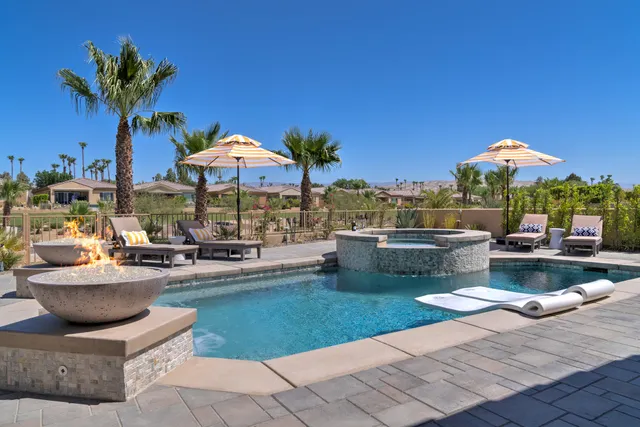 a patio with a table and chairs and potted plants