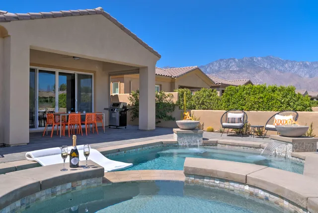 a view of a house with backyard sitting area and swimming pool