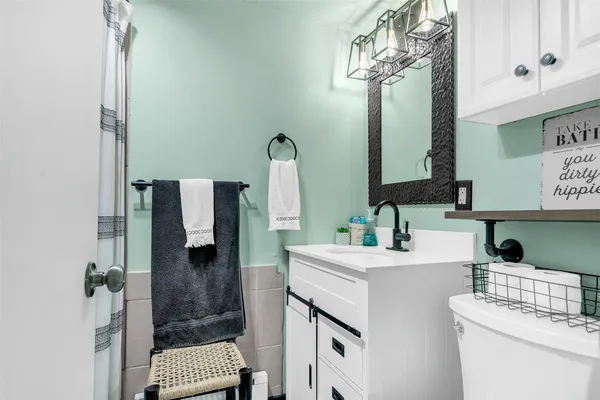 a bathroom with a sink a toilet and shower