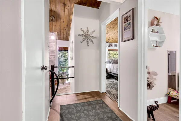 a view of a hallway with wooden floor and windows