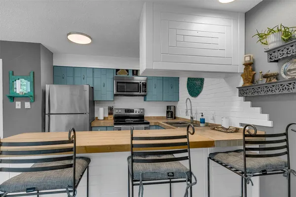a kitchen with a refrigerator a stove and a sink with wooden floor