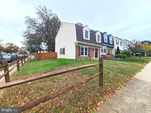 a view of a house with a yard and large trees