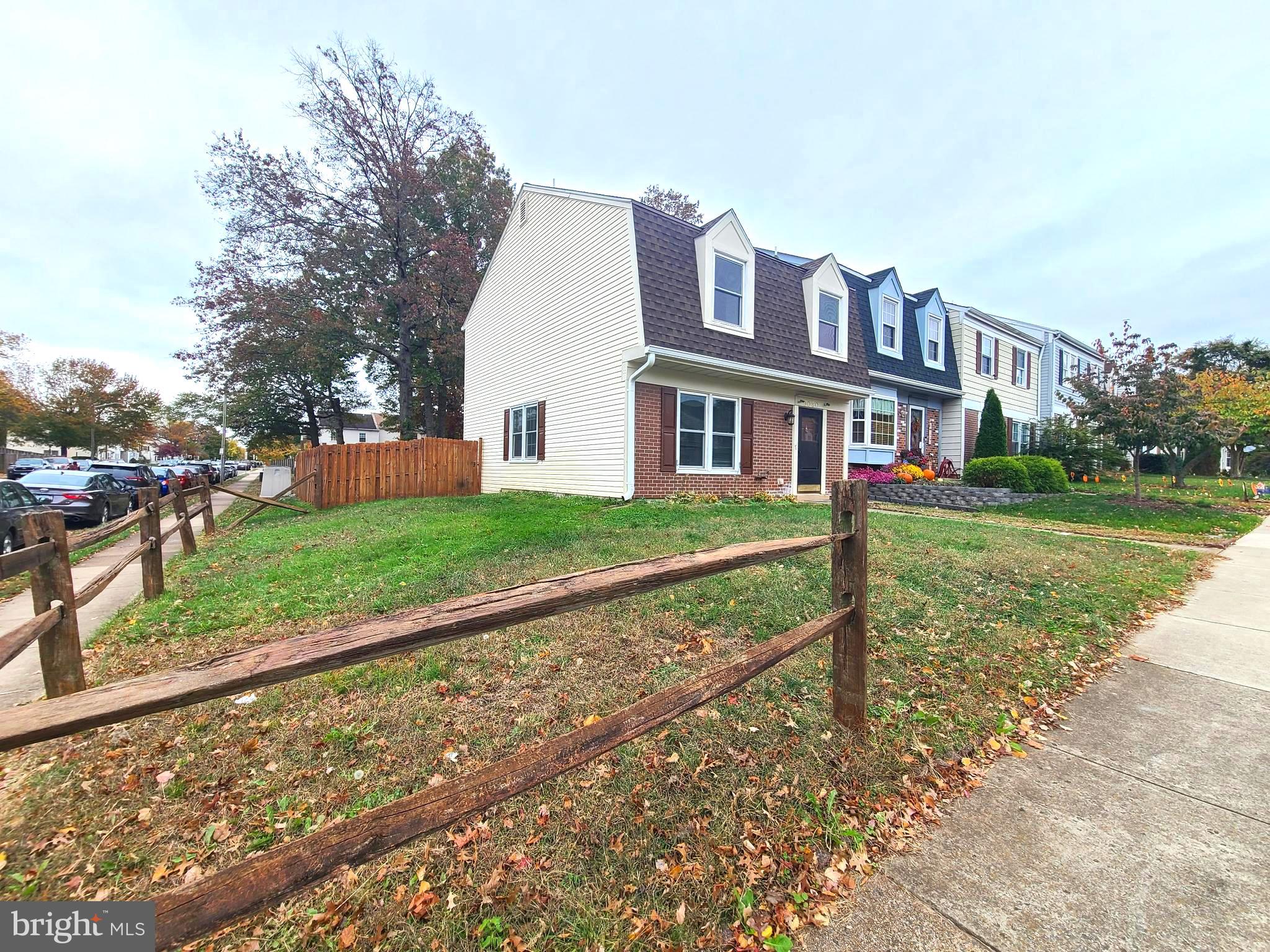 a view of a house with a yard and large trees