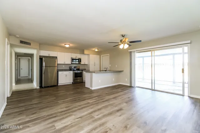 a view of a kitchen with a refrigerator a microwave and a sink