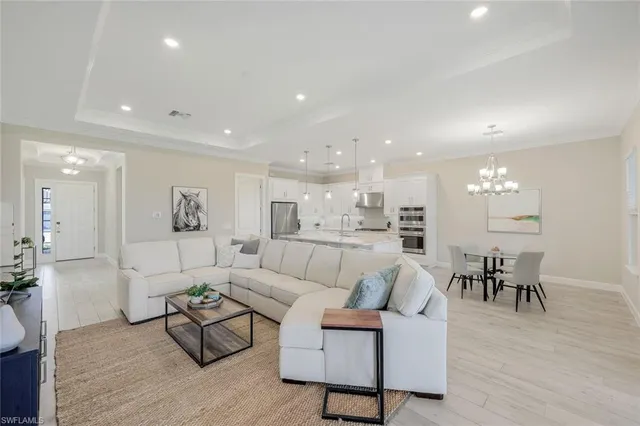 a living room with furniture and a dining table with wooden floor