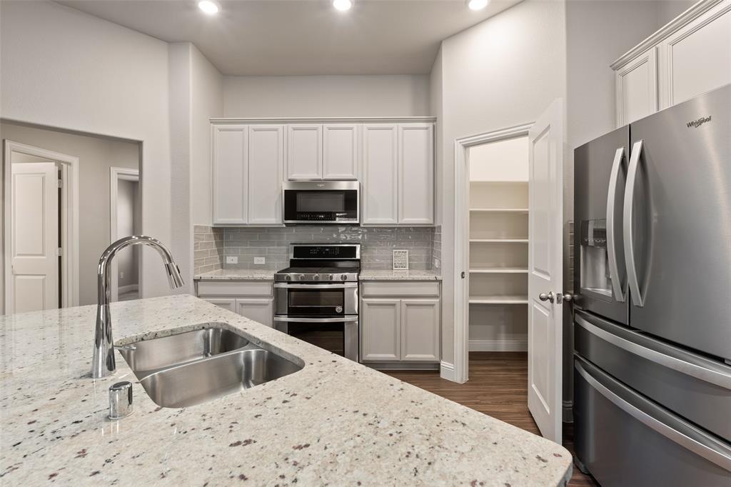 6909 Danridge Road Rowlett, TX 75089 - Photo 9 of 29 a kitchen with a refrigerator stove and sink