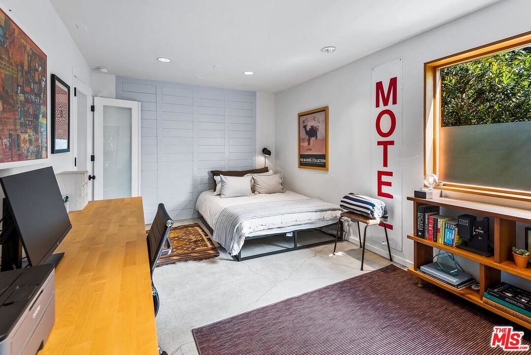 8544 Ridpath Drive West Hollywood, CA 90046 - Photo 24 of 34 a spacious bedroom with a bed and a flat screen tv