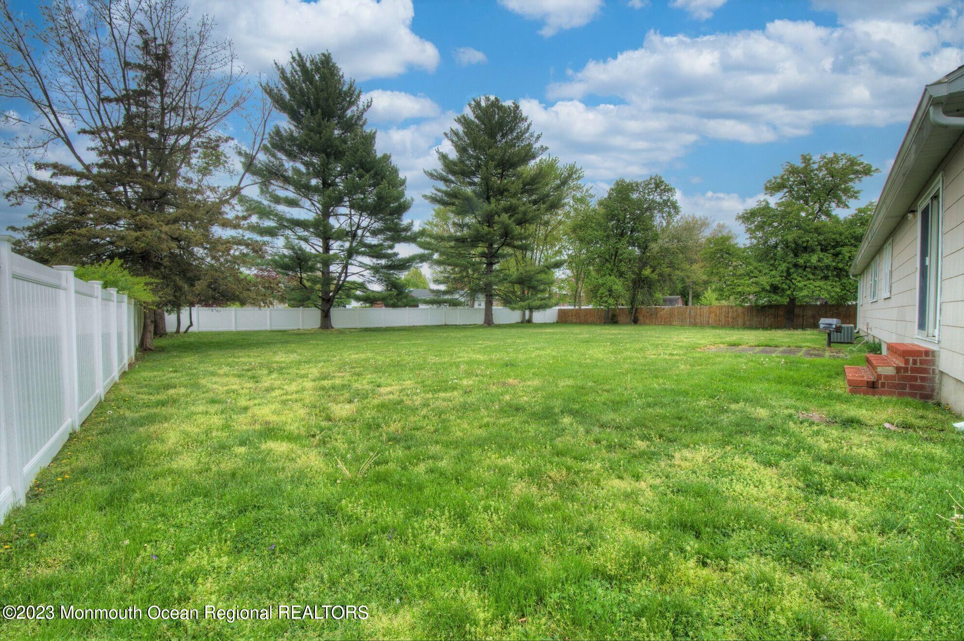 11 Woods Road Freehold, NJ 07728 - Photo 23 of 25 a view of a big yard with plants and large trees