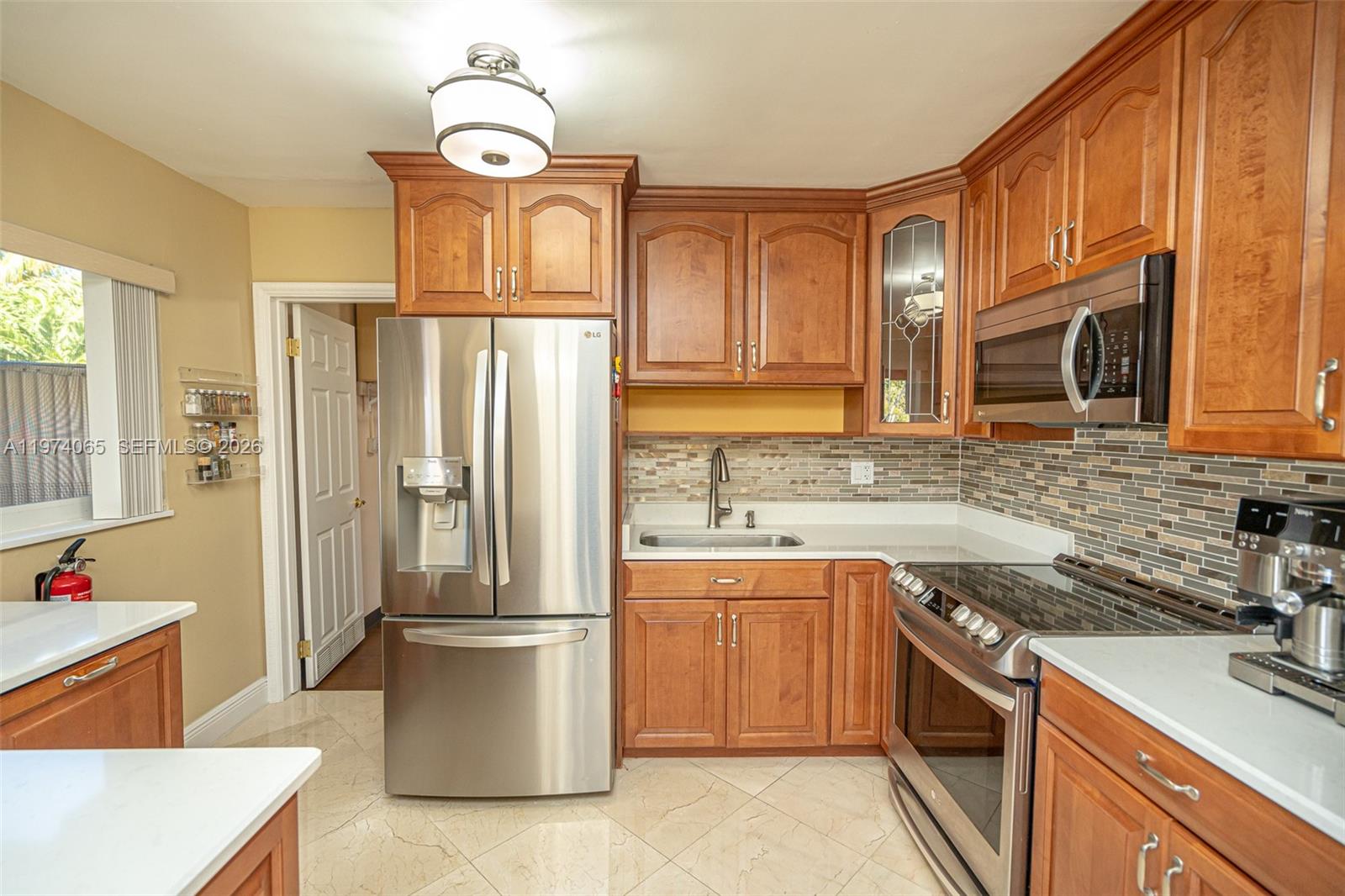 4600 Southwest 104th Avenue Miami, FL 33165 - Photo 25 of 40 a kitchen with stainless steel appliances granite countertop a refrigerator sink and stove
