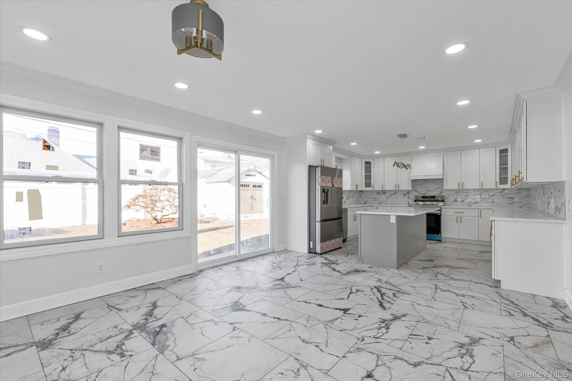 33 Prentice Road Levittown, NY 11756 - Photo 7 of 24 a large white kitchen with kitchen island a window a counter space and stainless steel appliances