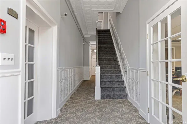 a view of staircase with lots of frames on wall and stairs